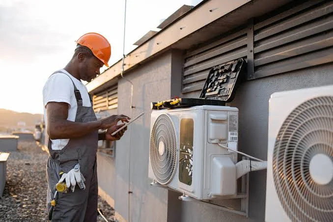Air conditioning technician inspecting outdoor cooling equipment