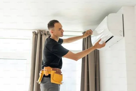 Home comfort technician adjusting indoor temperature controls